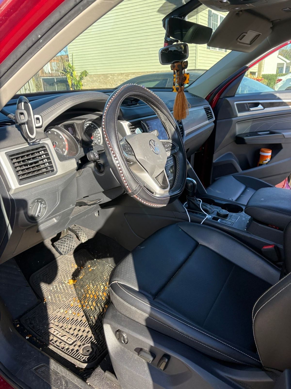 Volkswagen Atlas interior before detailing, with crumbs and debris on the floor mat