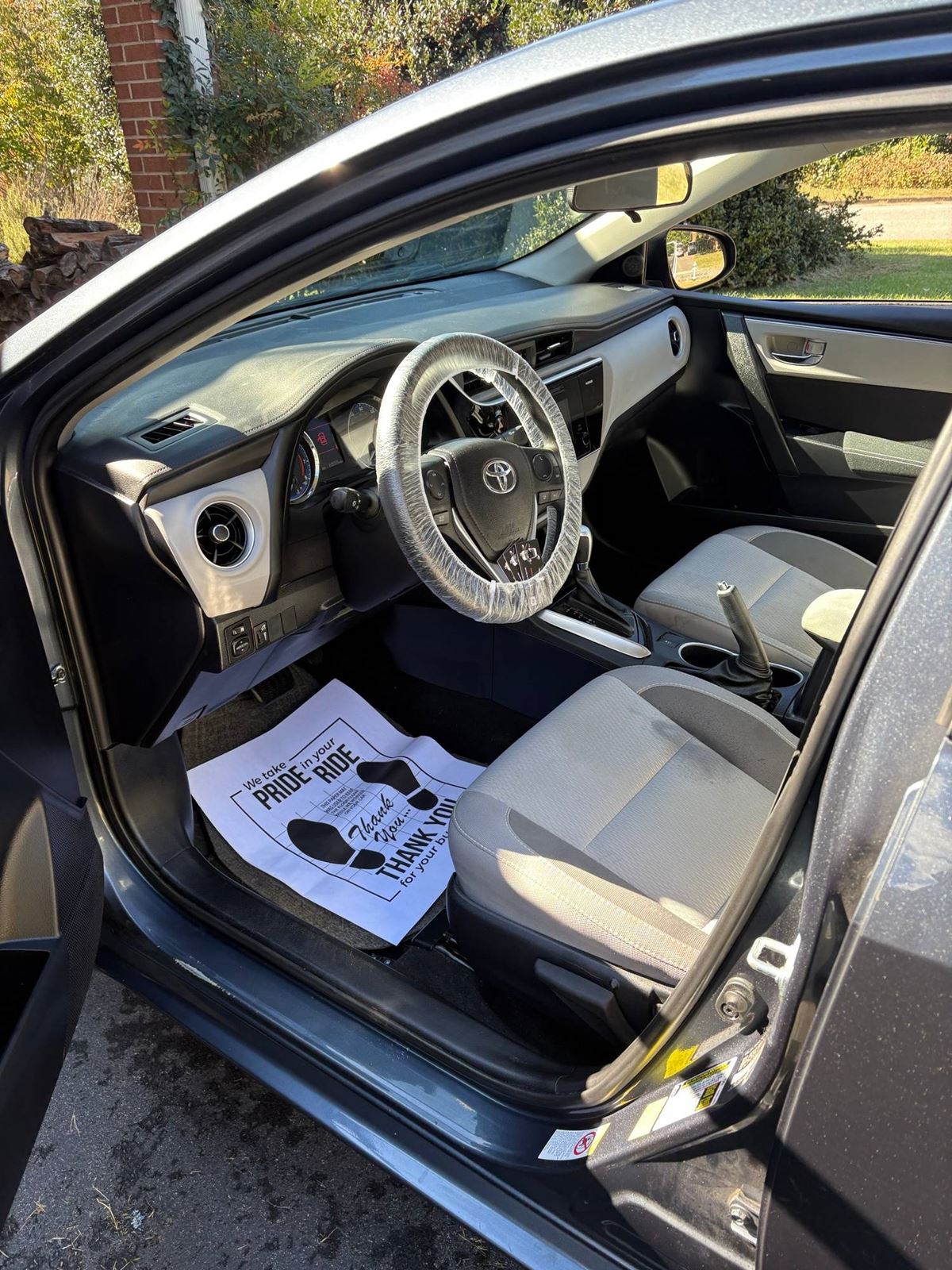 Toyota Corolla interior after detailing: clean dash, seats, and floor with a protective paper mat
